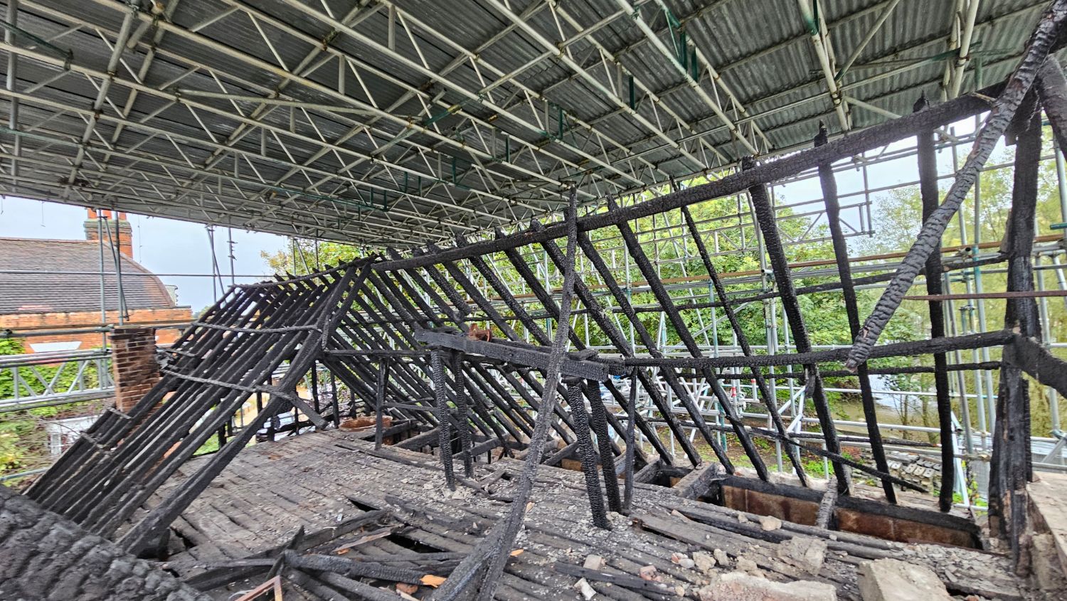 The charred rafters of the fire-damaged roof at East Bay Mill, Colchester, beneath the temporary scaffold roof